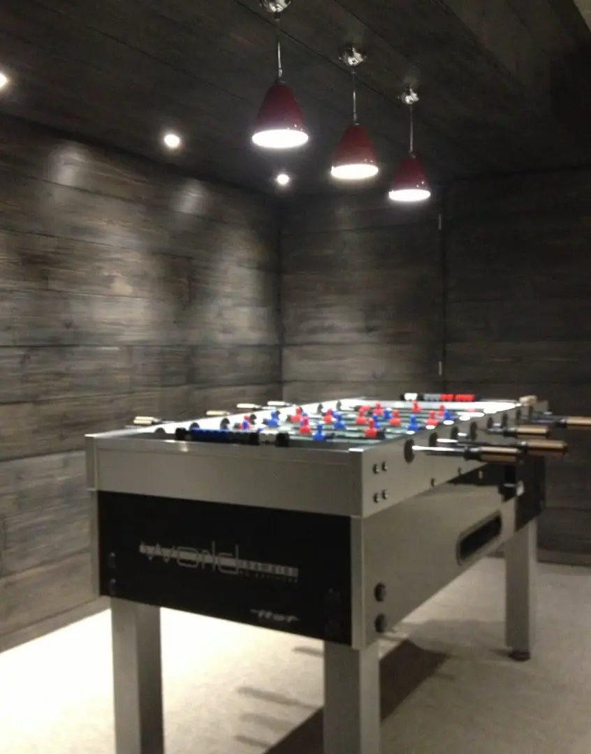 Modern games room foosball table lighting with red pendant fixtures